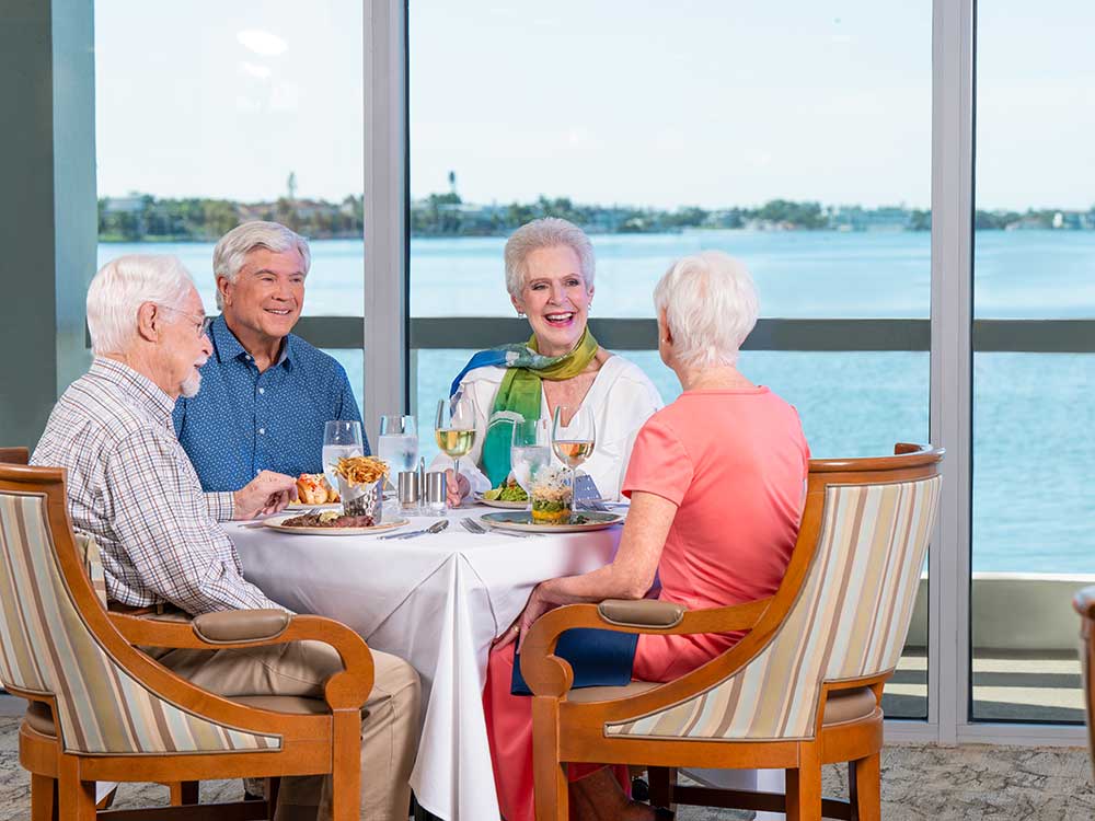 A group of seniors seating in the dining room at Plymouth Harbor on Sarasota Bay