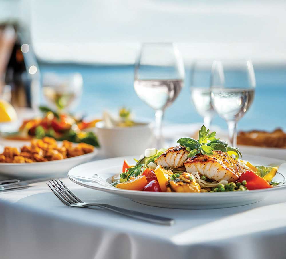 Plated meal on table with water view in the distance