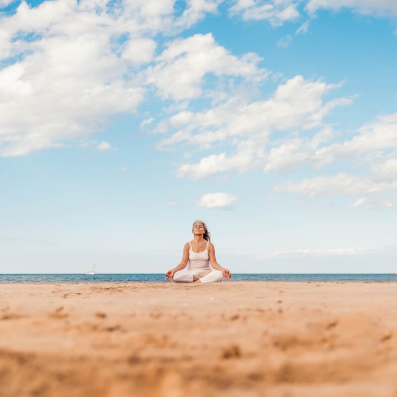 A resident meditating in front of the water.