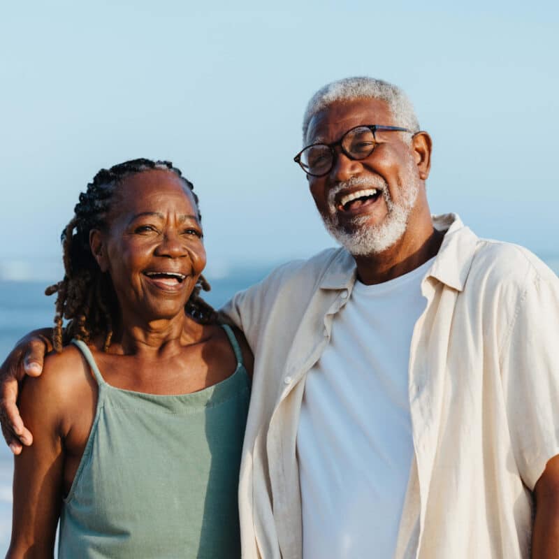 A couple standing in front of the water.