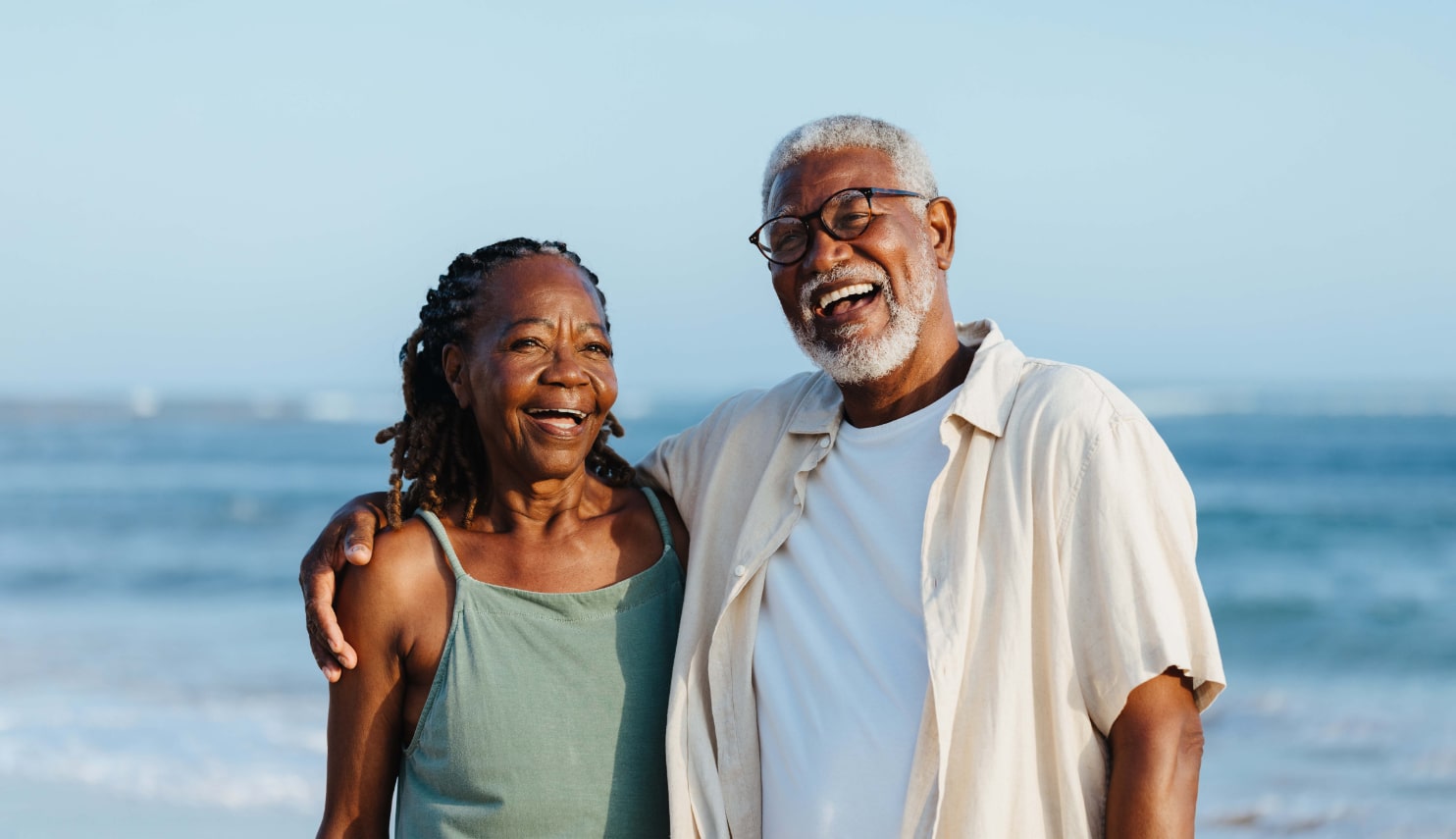 A couple standing in front of the water.